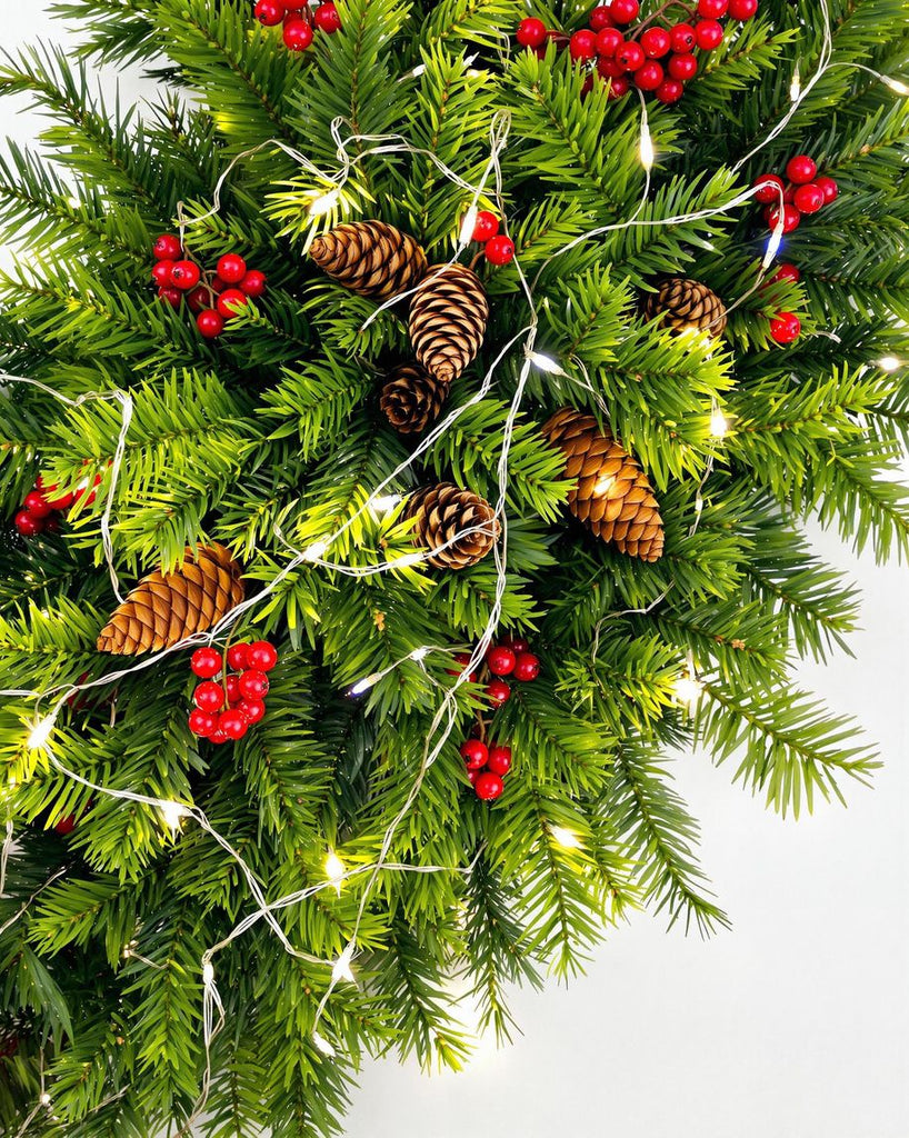 Christmas decorations with foliage, pine cones, and berries.